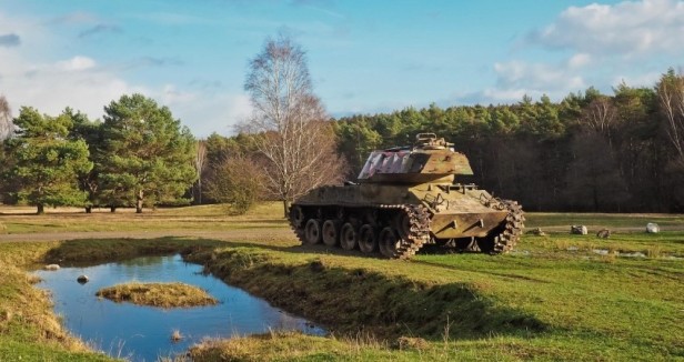 A tank rolls across a wildlife rich meadow in Grafenwöhr in Germany